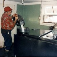 farmer Don pouring his milk in the creamery Pumpkin Vine Family Farm now uses.