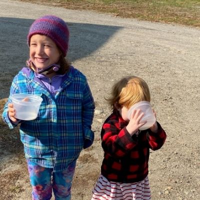 two girls drinking goat milk at the farm in Somerville Maine