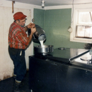 colored image of farmer Don pouring the milk into the cooler.